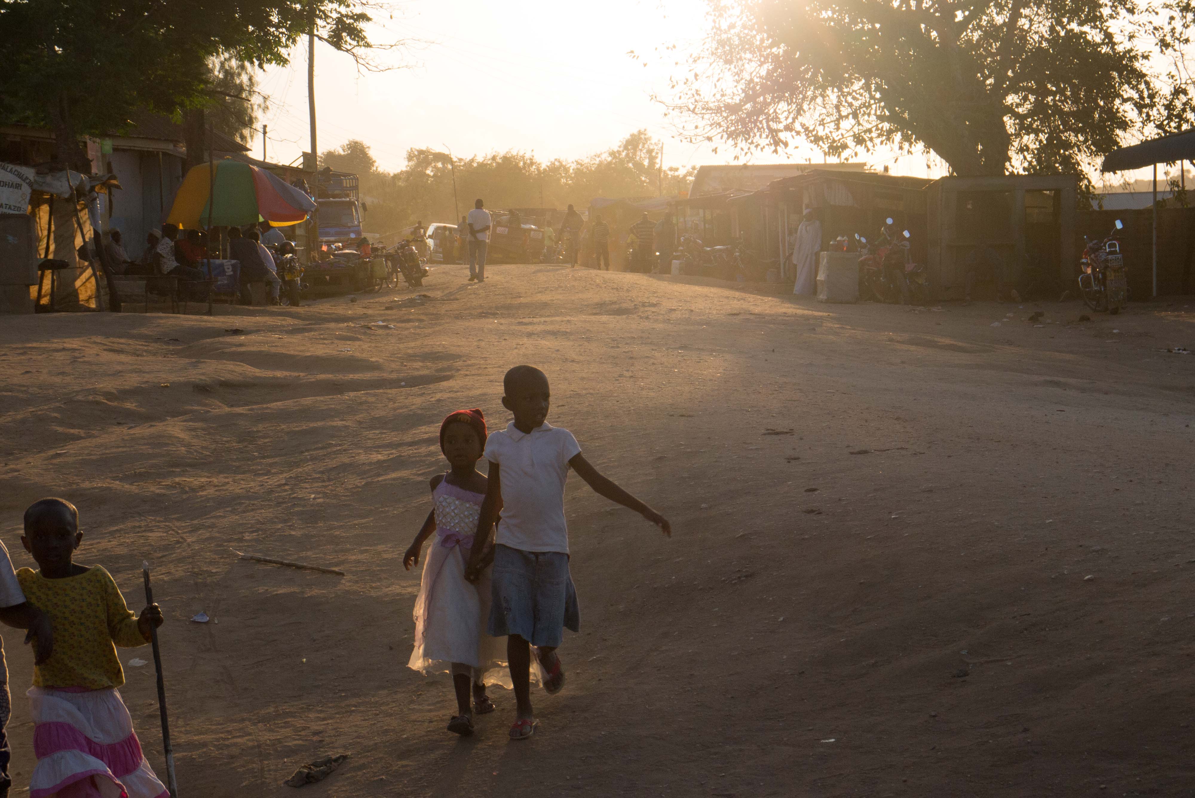 Children running forward against an evening sun in the village of Kibirashi